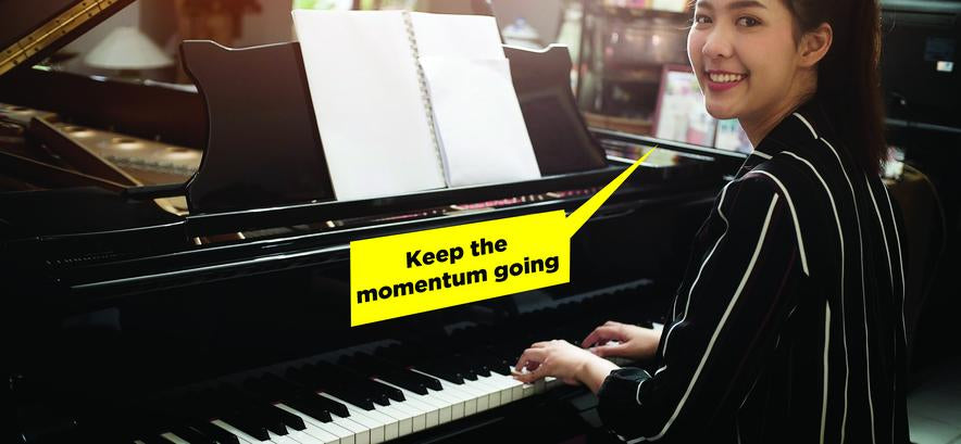 Asian woman at ground piano says "keep the momentum going"